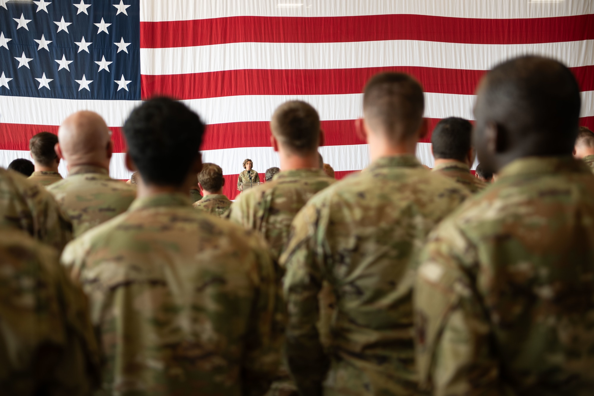 uniformed military members face an American flag