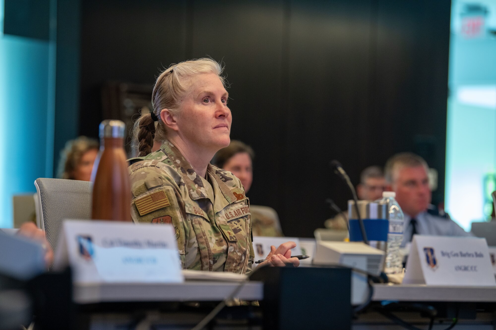 An uniformed woman listens to a presentation