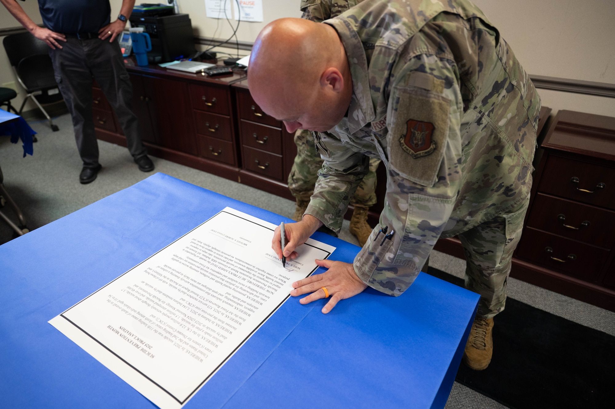 Chief Master Sgt Noel S. Price, 434th Air Refueling Wing command chief, signs the 2025 Suicide Prevention Month proclamation