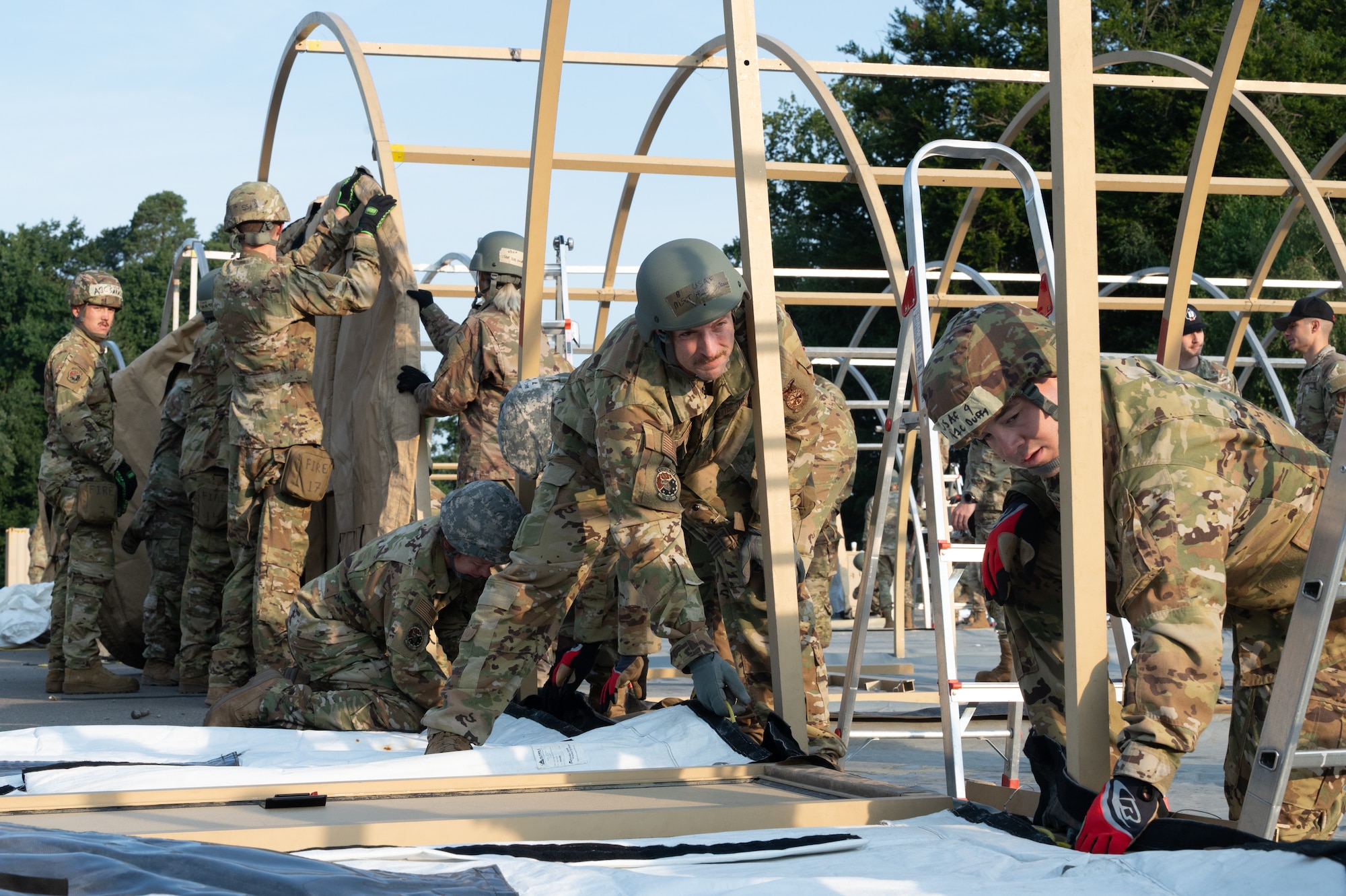 Airmen assigned to the 155th Civil Engineer Squadron, Nebraska Air National Guard, alongside active duty counterparts, assemble a tent encampment at Ramstein Air Base, Germany, Aug. 6, 2025.