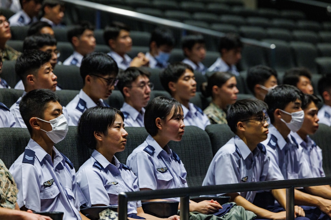 U.S. Marines stationed at Marine Corps Air Station Iwakuni and Japan Air Self-Defense Force cadets listen to a command brief before an installation tour at MCAS Iwakuni, Aug. 28, 2025. The tour gave JASDF cadets an overview of the installation's capabilities and gave them an opportunity to see a number of aircraft, such as the F-35B Lightning II, KC-130J Super Hercules, and C-12 Huron. (U.S Marine Corps photo by Cpl. Dahkareo Pritchett)