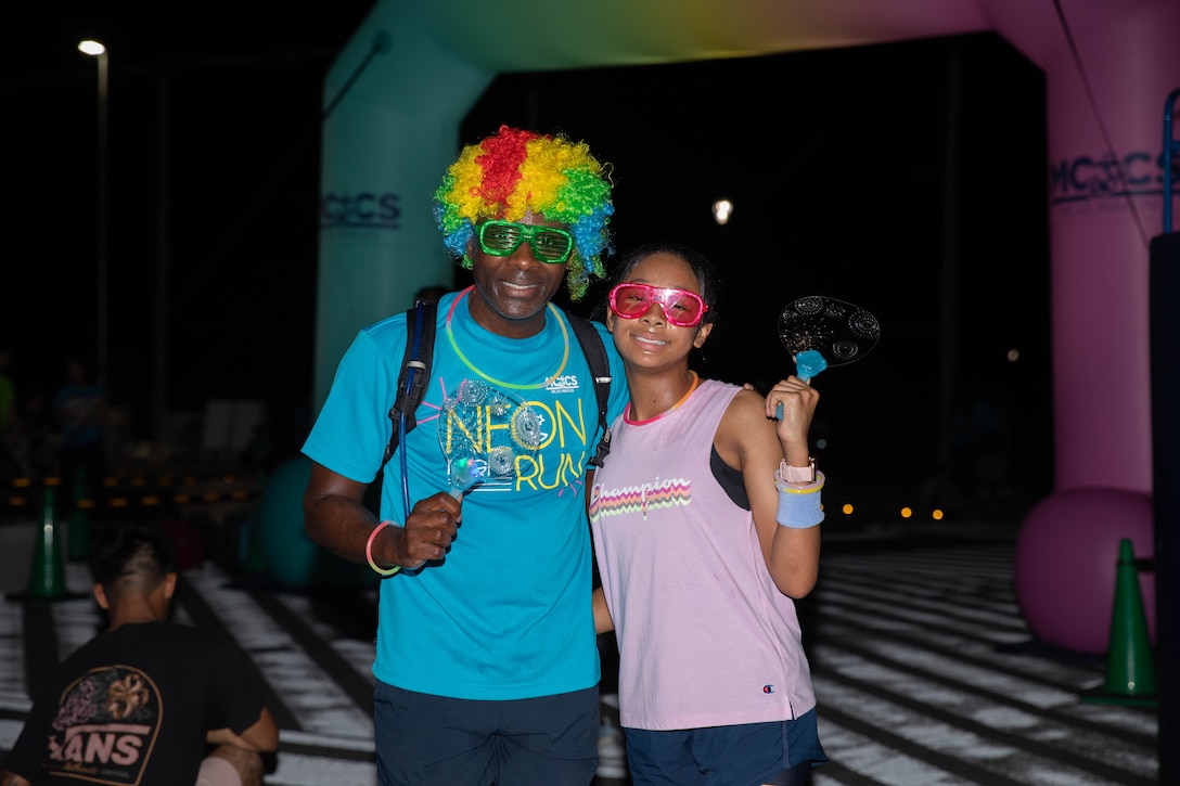 Participants pose for a photo after finishing the Marine Corps Air Station Iwakuni 2025 Neon Night Run at the Atago Sports Complex, Iwakuni, Japan, Aug. 22, 2025. The 2025 Neon Night Run, hosted by Marine Corps Community Services, consisted of warm-up Zumba dancing, a 2.7K family fun run, and raffle drawings for various prizes. (U.S. Marine Corps photo by LCpl. Siwan Lewis)