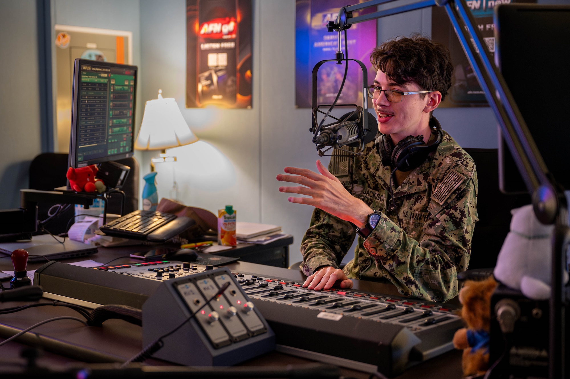 U.S. Navy Mass Communication Seaman Tyler Jackson, AFN Okinawa DJ, speaks live on air from the broadcasting studio at Camp Foster, Japan, Sept. 2, 2025. AFN Okinawa keeps service members and their families connected by delivering news, entertainment, and command information across the island. (U.S. Air Force photo by Airman Nathaniel Jackson)