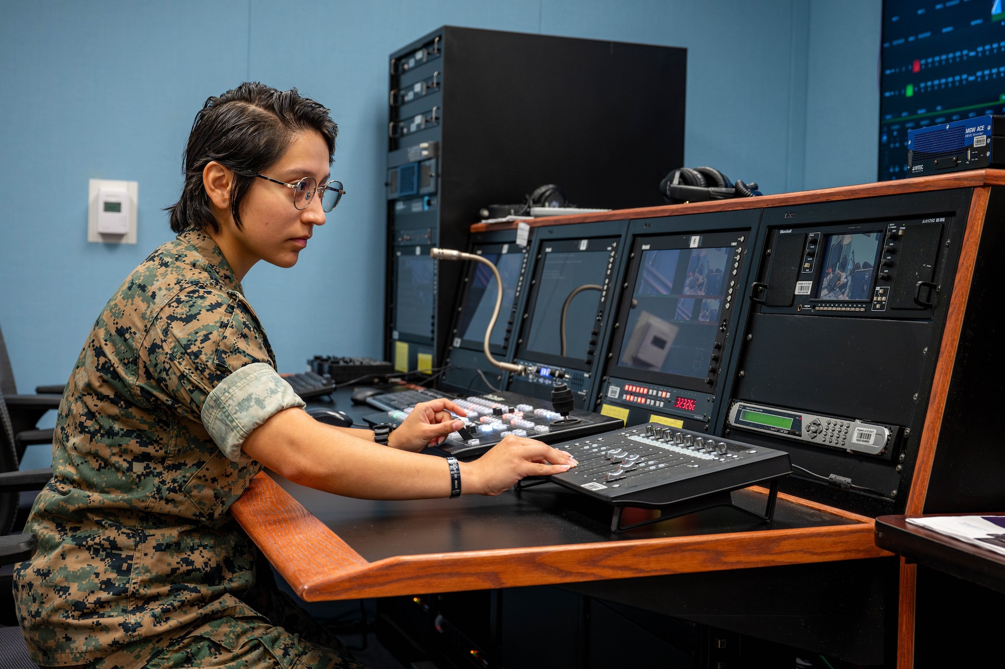 U.S. Marine Corps Sgt. Briana Vera, AFN Okinawa radio broadcaster, operates the studio board at Camp Foster, Japan, Sept. 2, 2025. From the control board, broadcasters can fine-tune audio levels and seamlessly switch between video sources in real time. (U.S. Air Force photo by Airman Nathaniel Jackson)