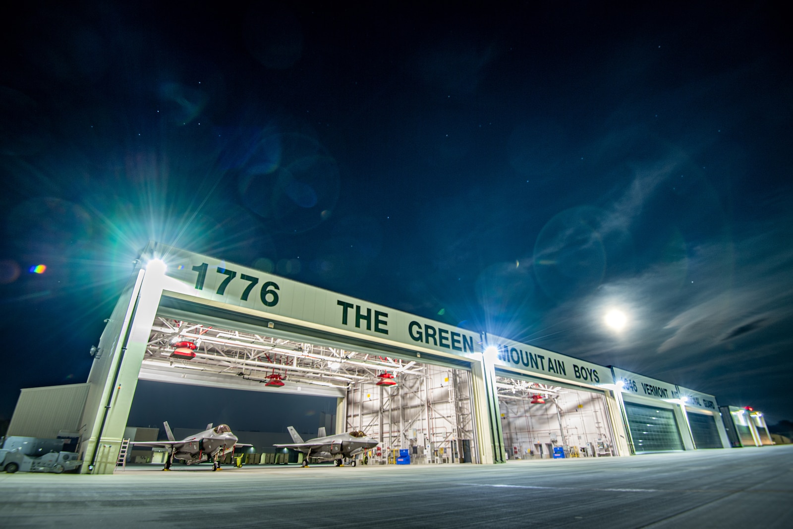Photo of Two F-35A Lightning II's assigned to the 134th Fighter Squadron of the Vermont Air National Guard's 158th Fighter Wing, siting under a hangar at the Vermont Air National Guard Base, South Burlington, Vermont, Sept. 17, 2024.