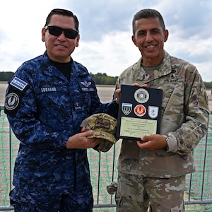 From left, Col. Pablo Soriano, chief of the Salvadoran Air Force, presents NH Adjutant Gen. David Mikolaities with a gift and plaque at the Thunder Over New Hampshire Air Show on Sept. 6, 2025, at Pease Air National Guard Base in Newington, N.H.