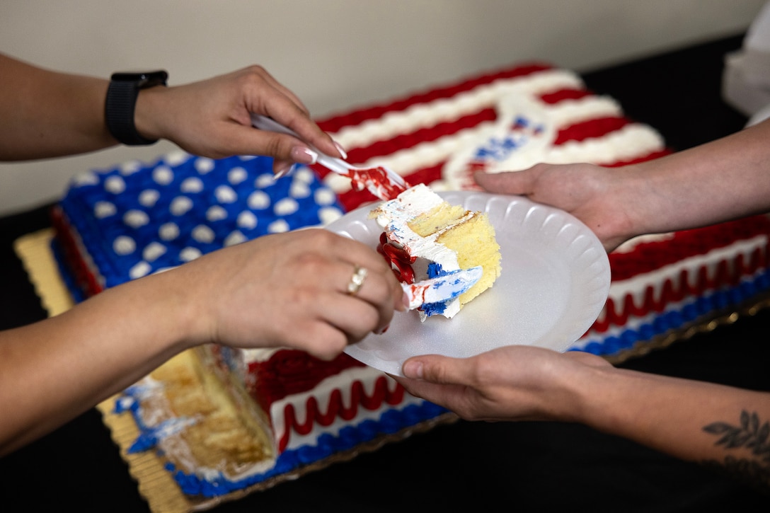 U.S. Marine Corps Sgt. Elizbeth Diazpilier of New York City, cuts a piece of cake for Sgt. Tatiana Corbeil of Sarasota, Florida, during Blount Island Command’s 39th birthday celebration Sept. 3, 2025, at Marine Corps Support Facility Blount Island in Jacksonville, Florida. The event honored the command’s nearly four decades of supporting the Marine Corps’ global reach and rapid response capabilities. (Offical Marine Corps Photo/Dustin Senger)