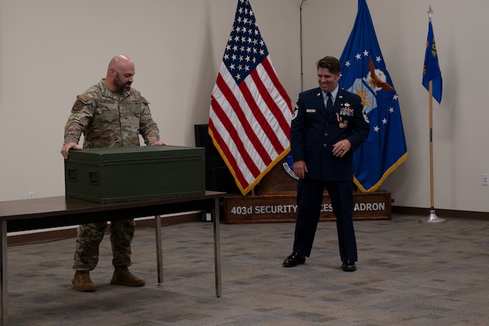 Senior Master Sgt. Daniel Ganus smiles as he is presented a shadow box.