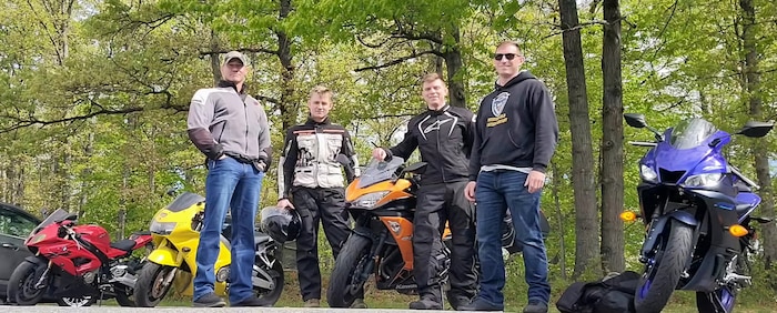 Retired U.S. Marine Corps Lt. Col. Dustin Kosar (left) poses for a photo with his students after coaching riding and stopping techniques to improve overall riding performance on Marine Corps Base Quantico, Virginia, on an unknown date in 2025. Kosar's motorcycle coaching passion began when one of his Marines nearly lost his life for improper handling of his motorcycle, leaving him permanently impaired for the rest of his life; the Marine was only 22 years' old when he crashed his motorcycle. Since then, Kosar coached Marines through motorcycle training programs offered in the Marine Corps units he was stationed at. He retired out of MCB Quantico and continues to coach Marines on safe handling of motorcycles on base through the Motorcycle Safety Foundation. “My passion right now is keeping Marines alive to enjoy the next ride,” Kosar stated. (U.S. Marine Corps courtesy photo)