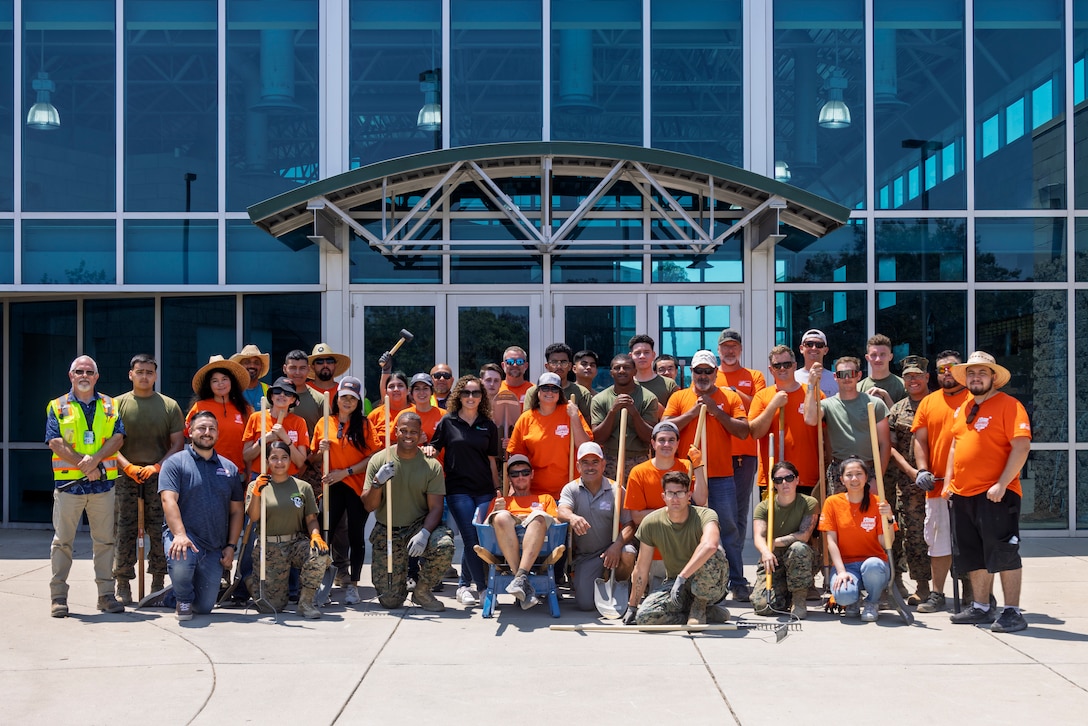 U.S. Marines stationed on Marine Corps Air Station Miramar and volunteers from a non-federal entity pose for a group photo for Operation Clean Sweep II at MCAS Miramar, California, Aug. 12, 2025. Marines and volunteers helped renovate the area around the joint reception center to improve quality of life on MCAS Miramar. (U.S. Marine Corps photo by Lance Cpl. Jackson Rush)