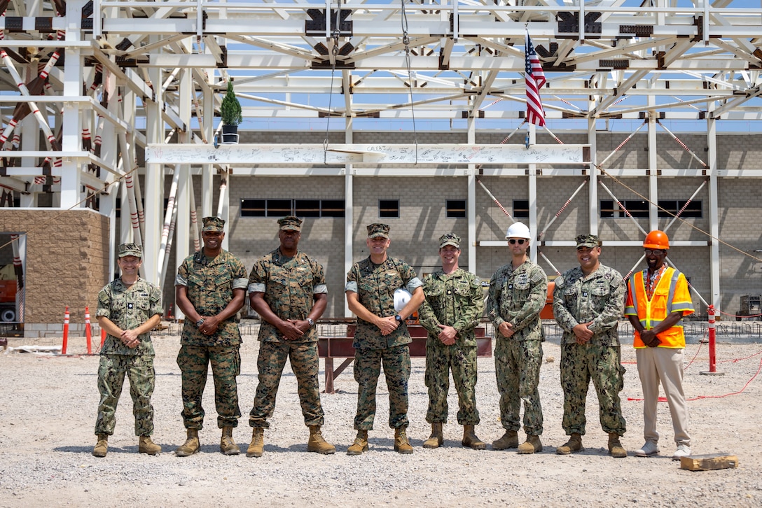U.S. Marine Corps and U.S. Navy leaders stationed on Marine Corps Air Station Miramar take a group photo in front of the final I-beam before its installation at the P-201 hangar during a construction topping out ceremony at MCAS Miramar, California, July 15, 2025. MCAS Miramar celebrates the installation of the final structural member at the P-201 hangar, recognizing the Harper construction team’s hard work and efficiency. (U.S. Marine Corps photo by Lance Cpl. Seferino Gamez)