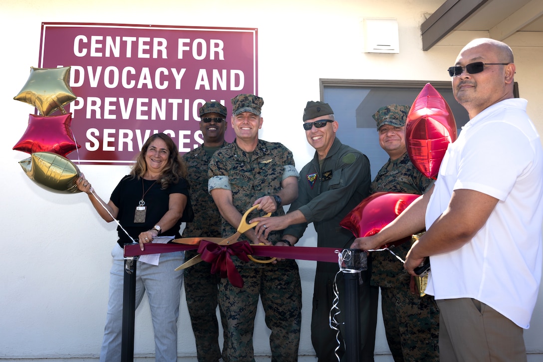 From left to right, Lori Saldate, the primary prevention integrator, Marine Corps Air Station Miramar, U.S. Navy Cmdr. Ferguson L. Harris, the chaplain for MCAS Miramar, U.S. Marine Corps Col. R. Erik Herrmann, the commanding officer of MCAS Miramar, Lt. Col. Luke T. Esposito, the former executive officer of MCAS Miramar, Sgt. Maj. Alejandro Garcia, the sergeant major of MCAS Miramar, and Stephen “SAPR Steve” Atienza, a sexual assault response coordinator, Marine Corps Air Station Miramar, pose for a photo during a ribbon cutting ceremony for the official opening of the Center for Advocacy and Prevention Services on MCAS Miramar, California, July 29, 2025. The CAPS, located on the western side of the postal office, is a new center where resources are consolidated to make sexual assault and prevention resources more prominent and easier to access for service members and spouses on the installation. (U.S. Marine Corps photo by Lance Cpl. Jackson Rush)