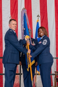 Chief Master Sgt. Marcia Evans receives the guidon from Col. Scott Hurrelbrink, 919th Special Operations Wing commander, during an assumption of responsibility ceremony at Duke Field, Fla., Sept. 6, 2025. The event symbolizes the trust and confidence placed in the wing’s top enlisted leader.