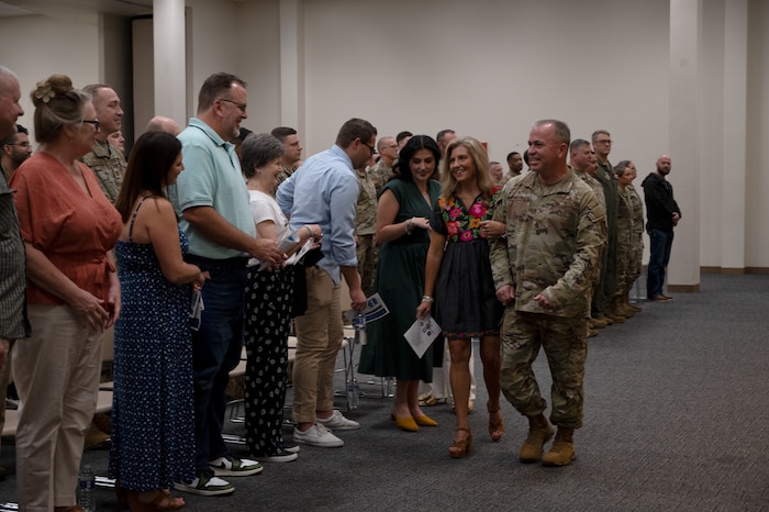 Lt. Col. Martin loops his arm with his wife as they walk past their family and friends.