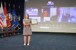 Woman standing alone holding a certificate