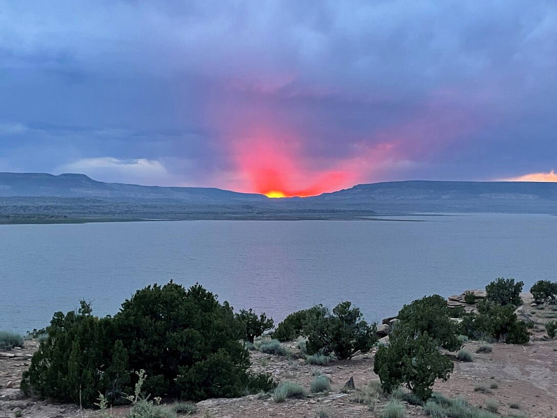 This sunset looks exactly like a Zia sun symbol tilted slightly on its side. The photo was taken July 14, 2024, at the Abiquiu Lake Cerrito Recreation Area by Pamela Bowie.