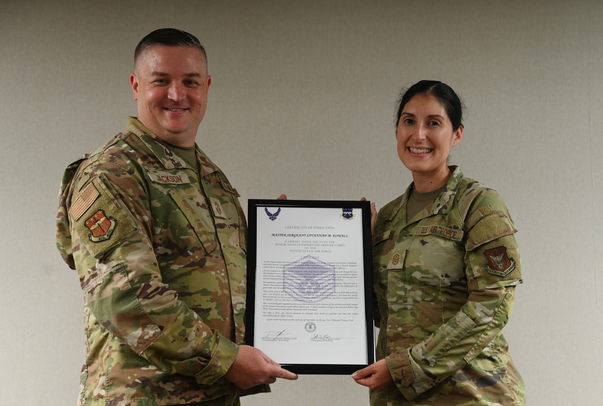 Chief Master Sgt. Jackson presents Master Sgt. Savannah Kowall an induction certificate.