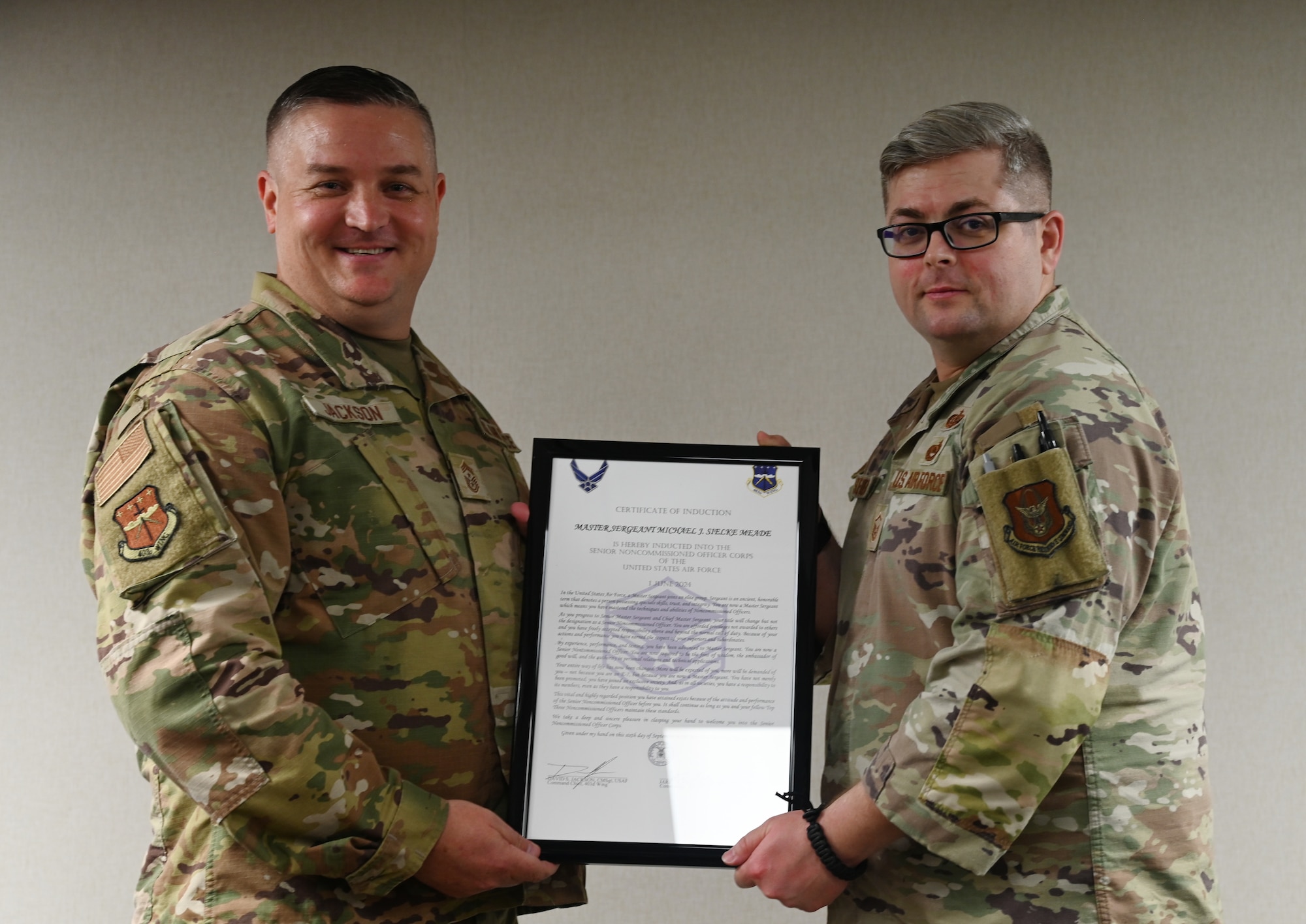 Chief Master Sgt. Jackson presents Master Sgt. Michael Sielke-Meade an induction certificate.
