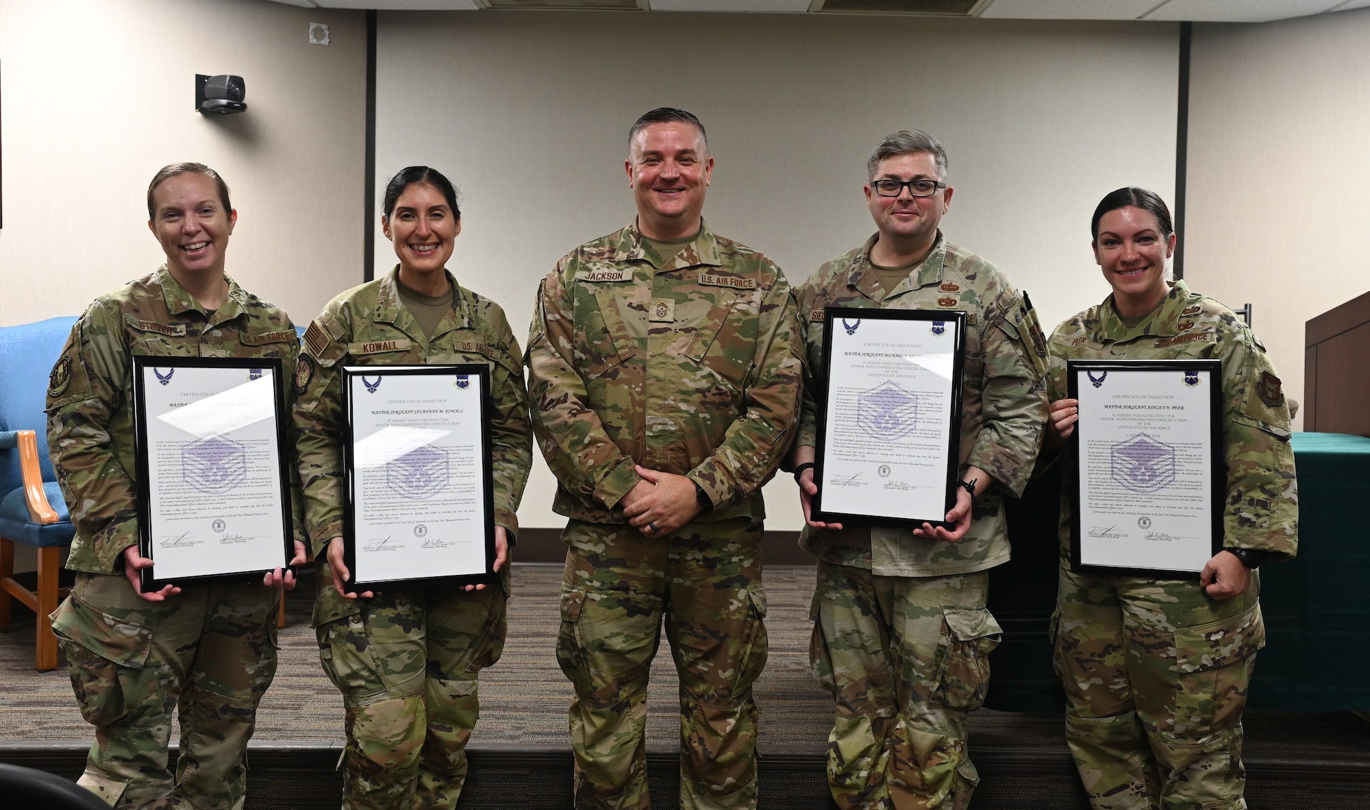 Master Sgt. inductees pose alongside the command chief with their certificates.