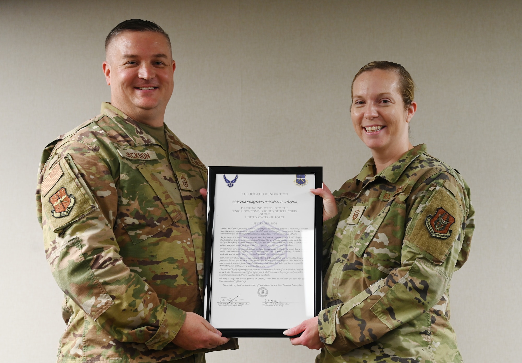 Chief Master Sgt. Jackson presents Master Sgt. Rachel Stover an induction certificate.
