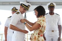 NAVAL STATION NORFOLK, VA (Jul. 25, 2025) Cmdr. Michael Schenk receives his Command-at-Sea pin as the Commanding Officer of the Arleigh Burke-class guided-missile destroyer USS Gonzalez (DDG 66) from his wife, Lacey. Gonzalez is the U.S. Navy’s 16th Arleigh Burke-class destroyer. The warship is homeported at Naval Station Norfolk and is a part of Destroyer Squadron 22, along with Carrier Strike Group 10, led by the USS George H.W. Bush. (U.S. Navy photo by Hull Maintenance Technician Third Class Xavier Wheeler).