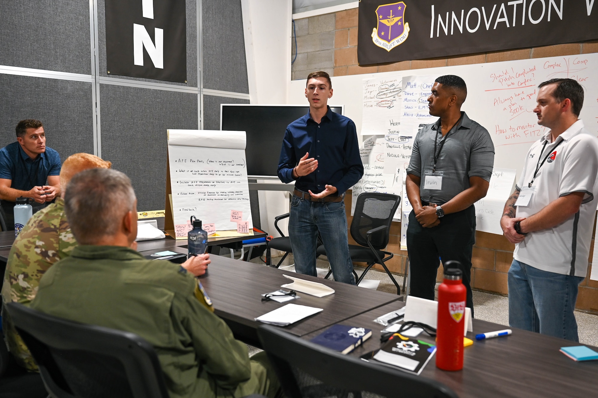Airmen gives presentation to table of Airmen.