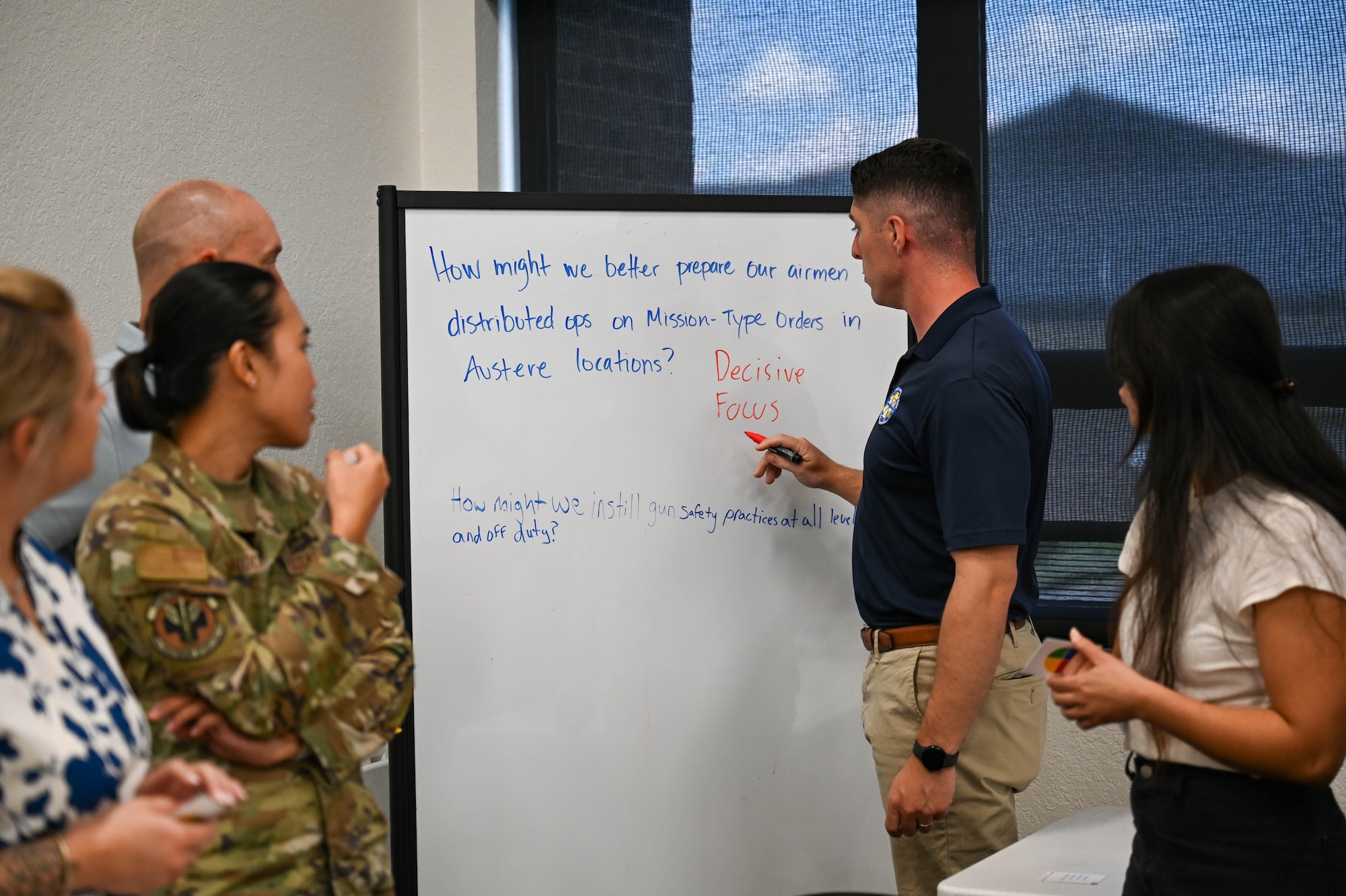Airmen writes on white board.