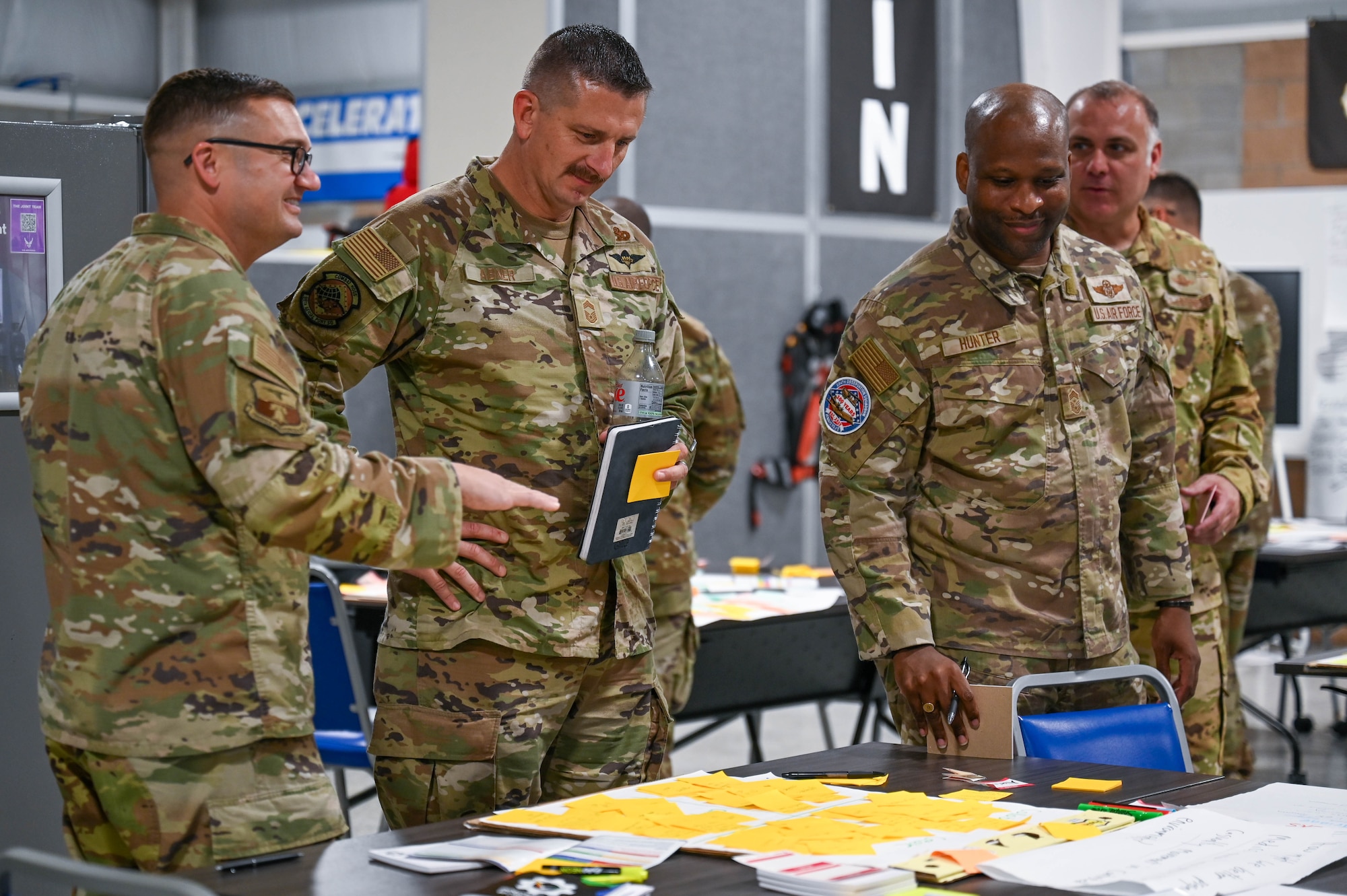 Airmen stand around table.