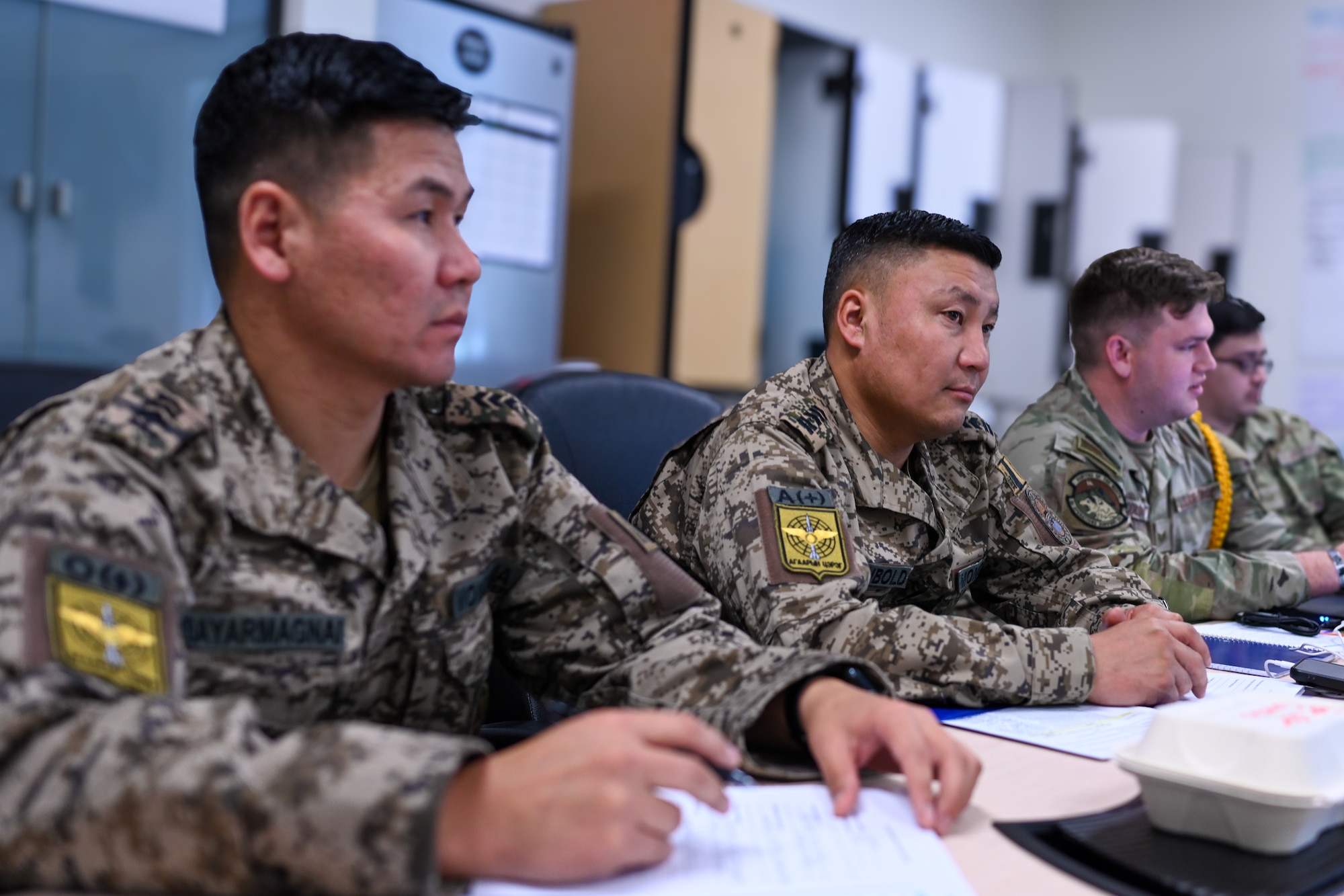 Mongolian Air Force Senior Master Sgt. Purevsuren Bayarmagnai and Chief Master Sgt. Erdenetsogt Aribunold listens during a briefing at the Elmendorf Non-commissioned Officer Academy on Joint Base Elmendorf-Richardson, Alaska, Sept. 4, 2025. Bayarmagnai and Aribunold were among a select group from the Mongolian Air Force attending various JBER professional military education courses to study and analyze military education methods to implement and improve them in their home nation. (U.S. Air Force photo by Airman 1st Class Eli A. Rose)