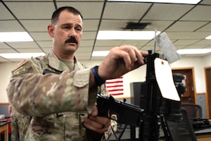 LUKE AIR FORCE BASE, Ariz. – Tech. Sgt. Steven Boatright, 944th Security Forces Squadron combat arms training and maintenance instructor, adjusts a rifle during combat arms duties at Luke AFB, Ariz., Aug. 8, 2025. He says his mission remains the same across all uniforms — to serve, protect and uplift others. (U.S. Air Force photo by Tech. Sgt. Tricia Topasna)