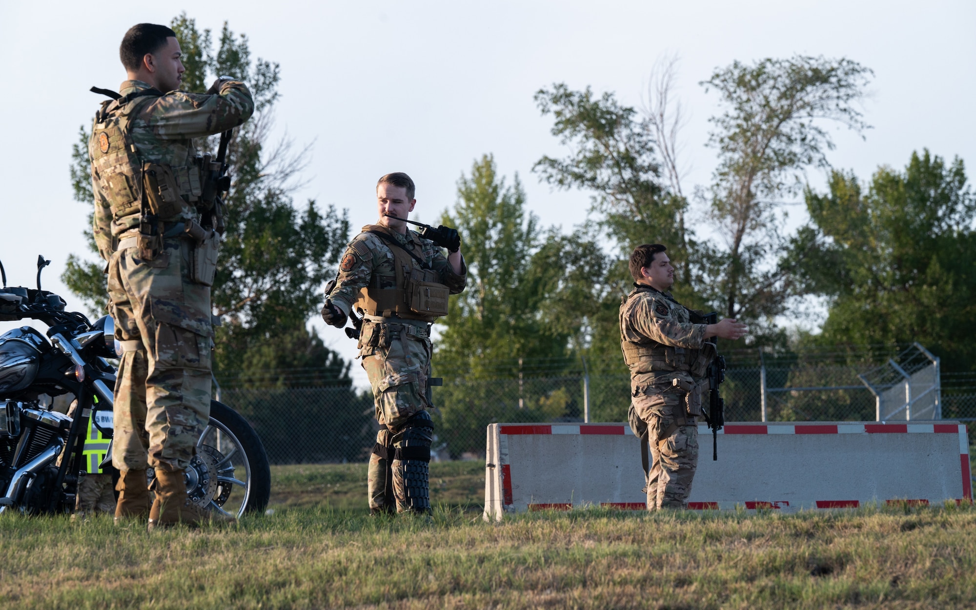 Airmen from the 5th Security Forces guide traffic through the Magic City Gate during a simulated demonstration at Minot Air Force Base, North Dakota, Sept. 3, 2025. The simulated demonstration was a part of Warbird Week, a routine exercise that ensures Airmen remain prepared to protect Minot AFB assets and respond to real-world incidents.