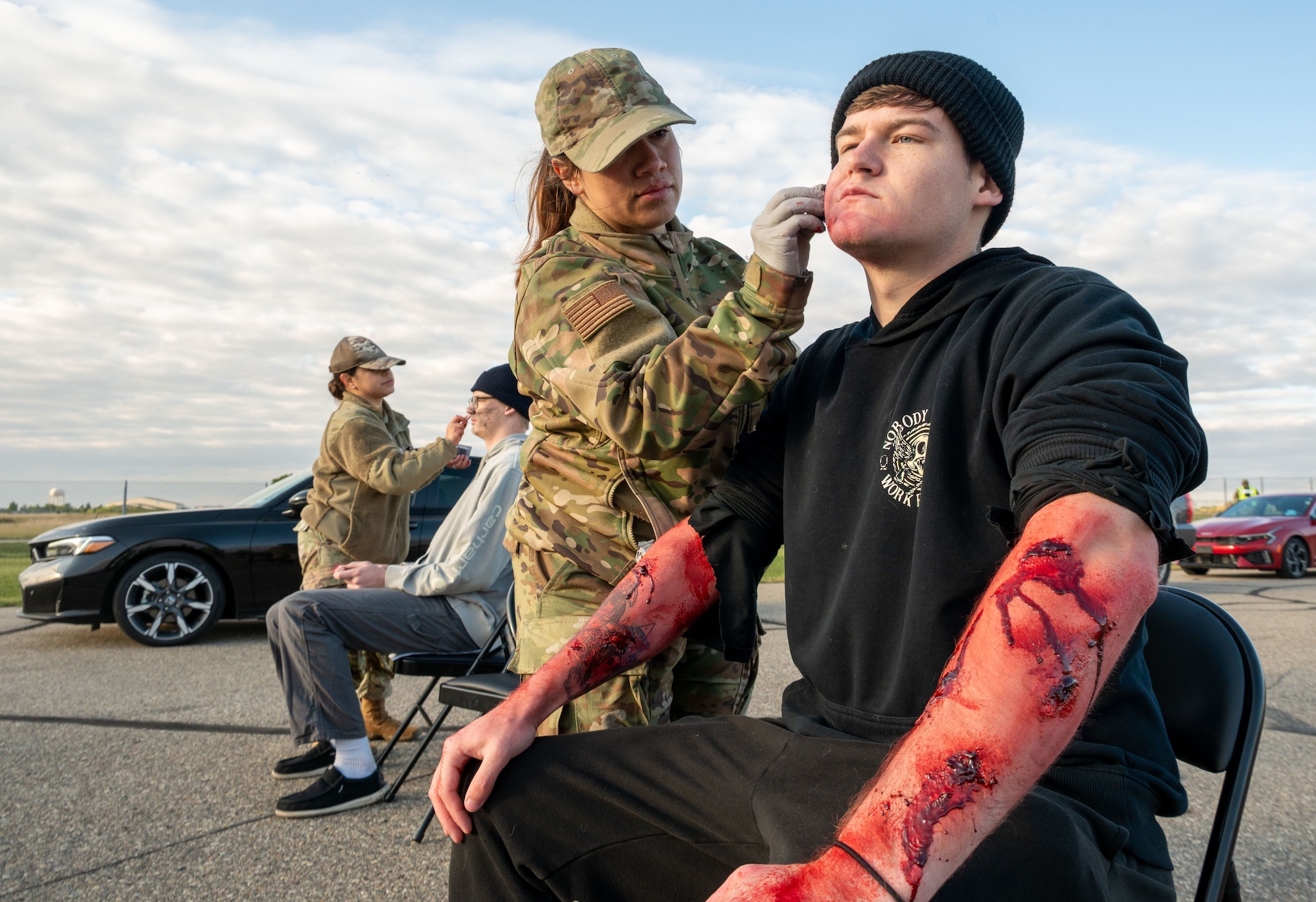 Members of the 5th Medical Group apply moulage to Airmen as part of a Warbird Week exercise at Air Force Base, North Dakota, Sept. 6, 2025. The realistic injuries help enhance training scenarios and prepare responders for real-world emergencies.