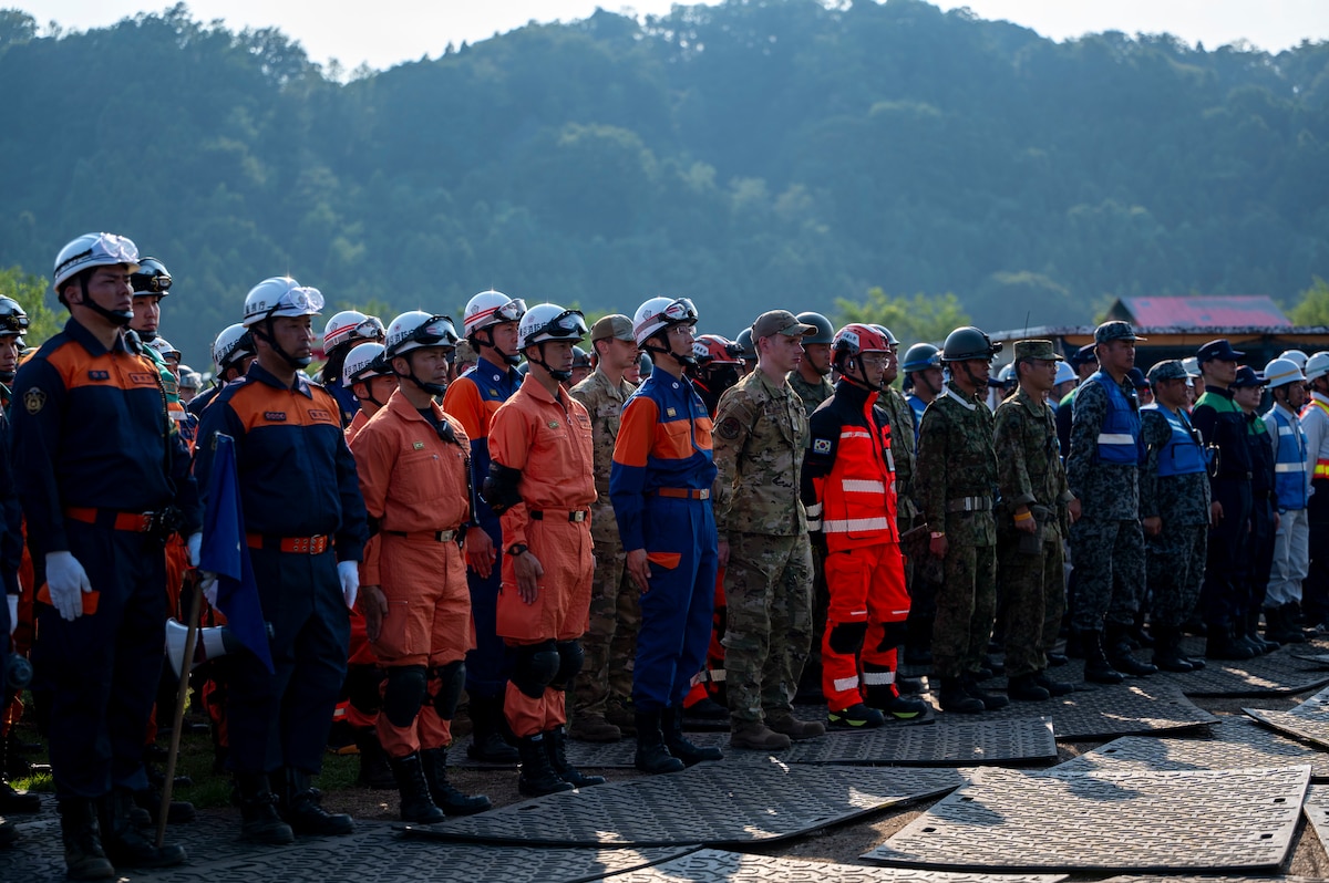 U.S. Air Force Airmen and Japanese fire department members stand in formation.