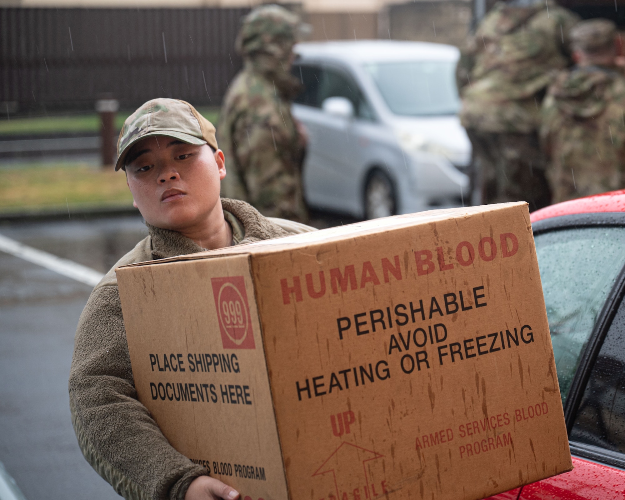 A U.S. servicemember carries a box labeled "Human Blood"