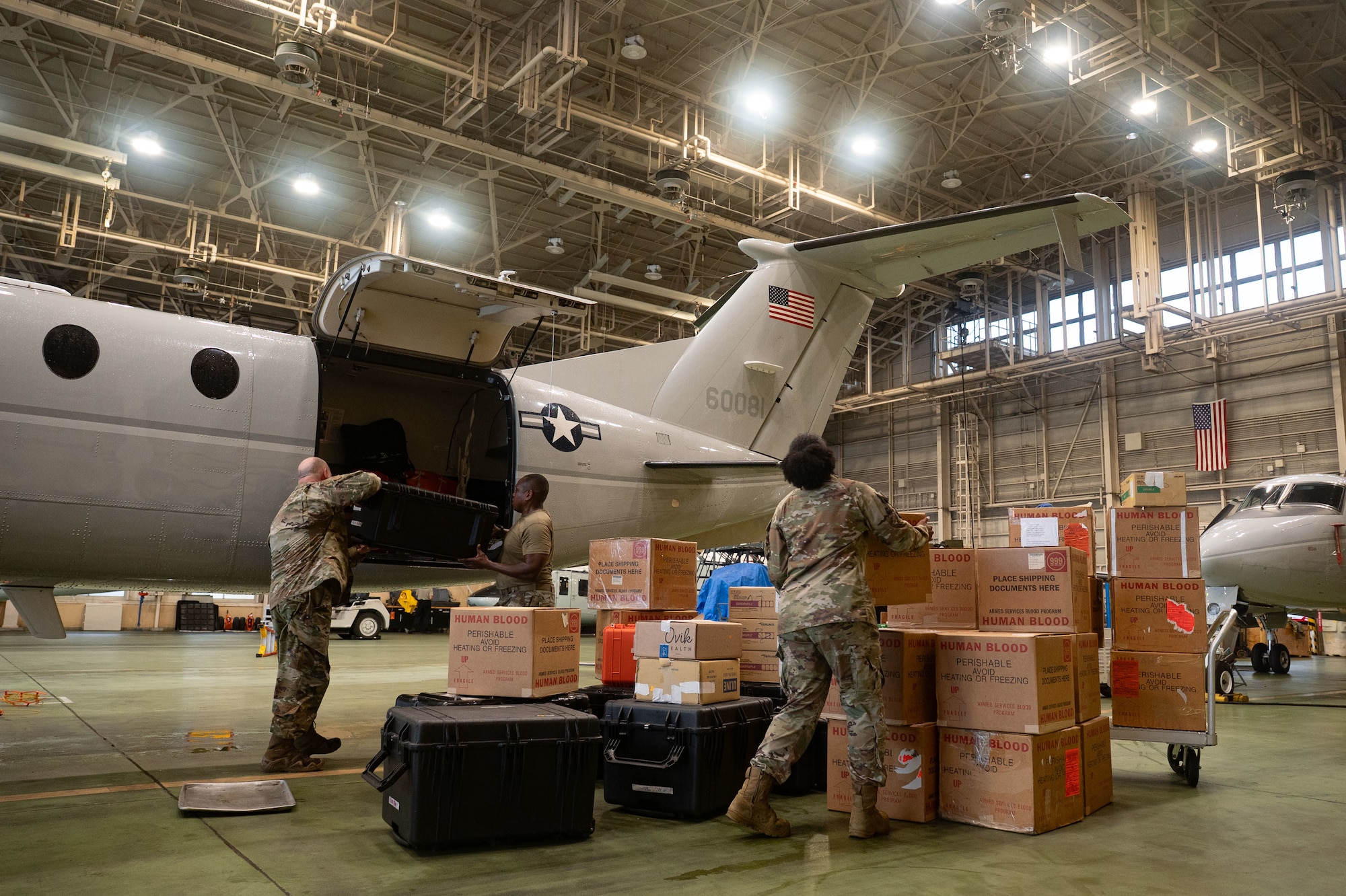 U.S. servicemembers prepare to move boxes into an aircraft