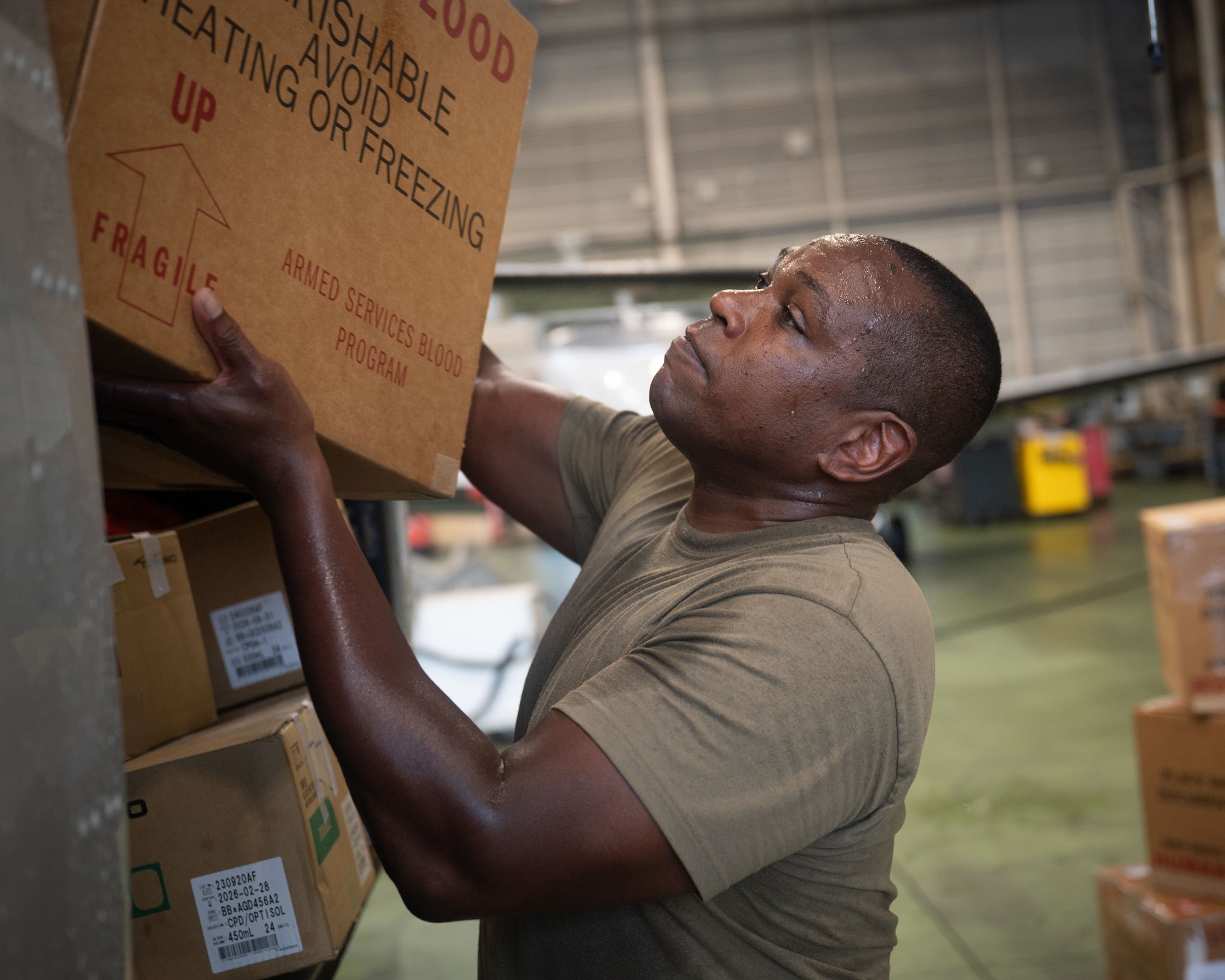 A U.S. servicemember places a box into an aircraft