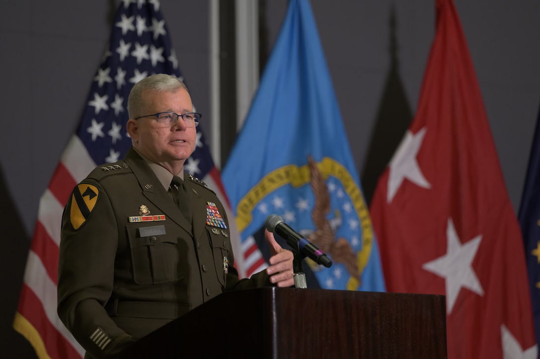 DLA Director speaking at podium.
