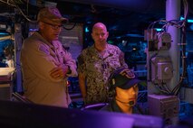 Acting Chief of Naval Operations Adm. Jim Kilby speaks with Capt. Nathan Diaz, commanding officer of the Ticonderoga-class guided-missile cruiser USS Normandy (CG 60), in the ship’s combat information center during Large Scale Exercise (LSE) 2025, August 5, 2025. LSE 2025 integrates participants from six U.S. Navy and U.S. Marine Corps component commands and seven U.S. numbered fleets across 22 time zones and is intended to refine how we synchronize maritime operations on a global scale. (U.S. Navy photo by Mass Communication Specialist 1st Class Nathan T. Beard)