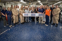 NORFOLK (July 28, 2025) Sailors assigned to the Wasp-class amphibious assault ship USS Iwo Jima (LHD 7) and United Service Organization (USO) staff take a group photo during a ribbon cutting ceremony. The event acknowledges the grand opening of the first USO ship-based recharge centers on an amphibious assault ship. Iwo Jima is the flagship of the Iwo Jima Amphibious Ready Group (ARG) which is capable of conducting global missions to accomplish U.S. strategic goals, deter adversaries, and ensure unimpeded commerce by keeping the high seas open and free in accordance with international law. Embarked aboard ARG shipping is the 22nd MEU (SOC) and provides a forward-deployed, flexible sea-based Marine Air Ground Task Force (MAGTF) capable of conducting amphibious operations—to include enabling the introduction of follow-on forces and designated special operations to meet Combatant Commander’s requirements. (U.S. Navy photo by Mass Communication Specialist 1st Class Erickson B. Magno)