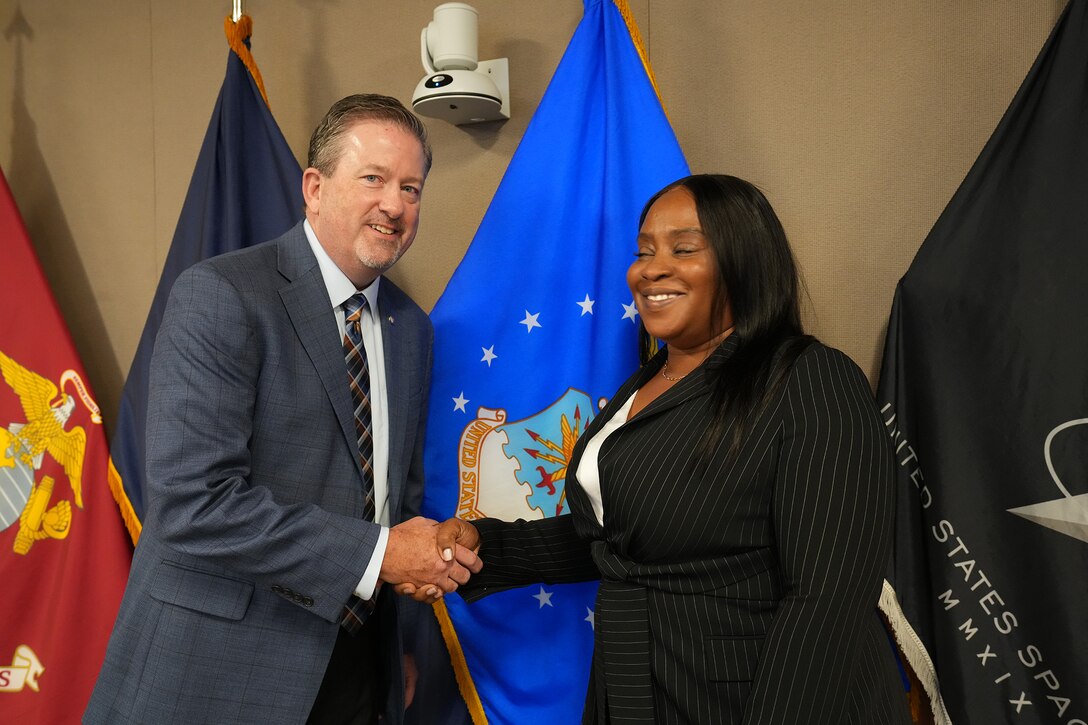 Man and woman pose with award.