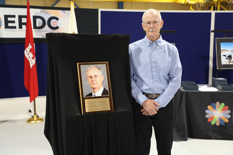 Randy Hill poses next to the plaque honoring his induction into the Cold Regions Research and Engineering Laboratory’s Gallery of Distinguished Employees.