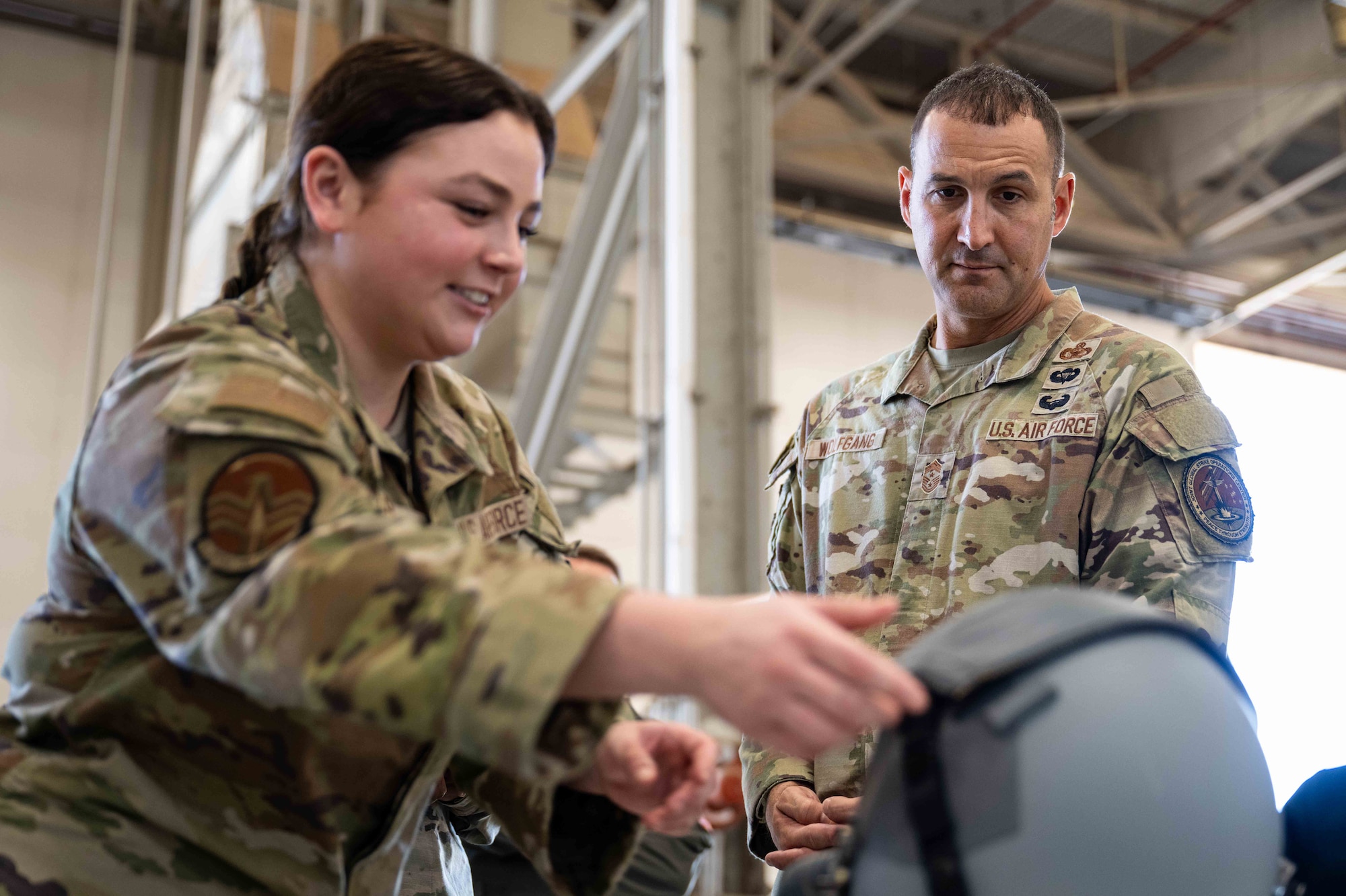 U.S. Air Force Airman 1st Class Anna Allen, 7th Operations Support Squadron aircrew flight equipment technician, briefs Chief Master Sgt. Brandon Wolfgang, Eighth Air Force command chief and Joint-Global Strike Operations Center senior enlisted leader, during a base tour at Dyess Air Force Base, Texas, Sept. 3, 2025. Wolfgang met with Airmen from AFE, aerospace physiology and ammunitions to discuss their day-to-day and role in supporting the bomb wing’s mission. (U.S. Air Force photo by Senior Airman Jade M. Caldwell)