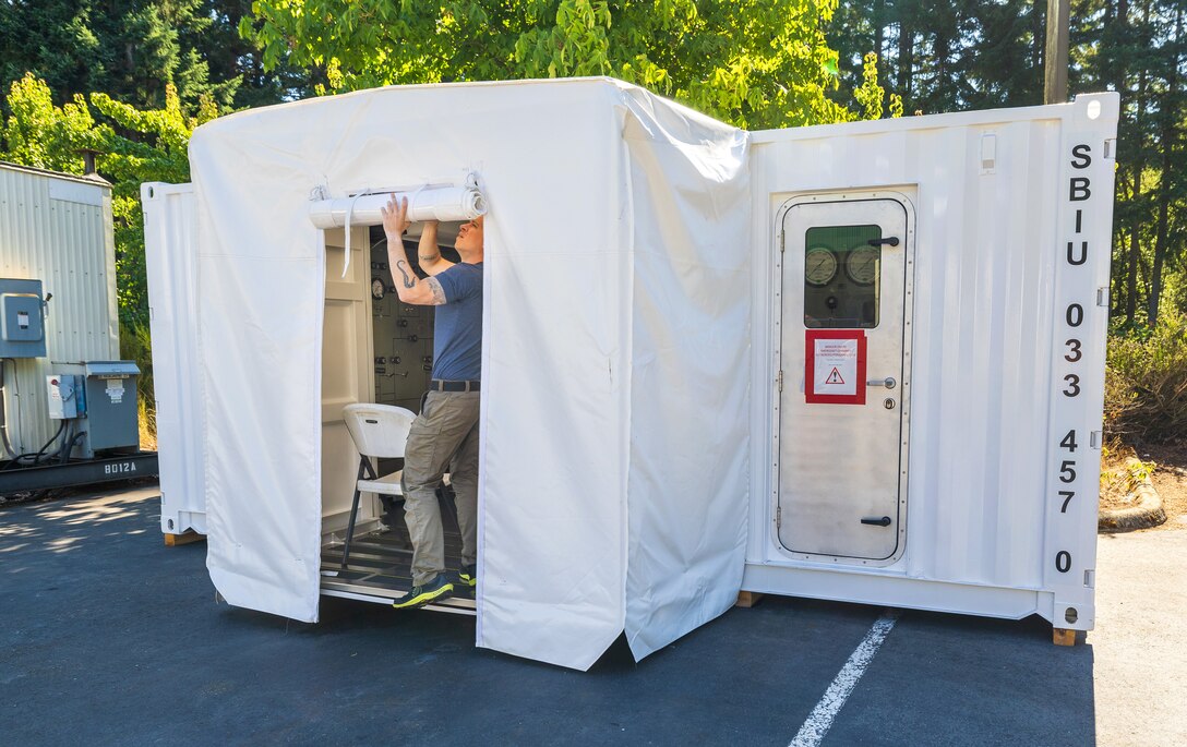 Navy Diver 1st Class Josh Amberson prepares the Bangor Dive Locker's new transportable Hyperbaric Chamber on Naval Base Kitsap-Bangor, Washington, July 29, 2025. (U.S. Navy photo by Wendy Hallmark)
