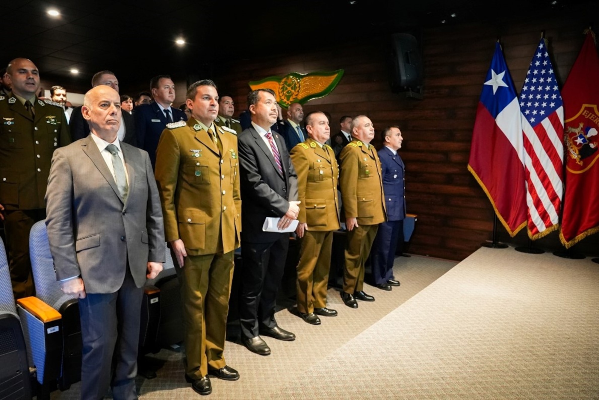 Senior leaders from Carabineros de Chile, the U.S. Embassy in Santiago, and U.S. and Chilean military organizations stand for the national anthems during the inaugural International Seminar on Operational Safety and Countering the Use of Unmanned Aerial Systems at the Carabineros Air Prefecture.