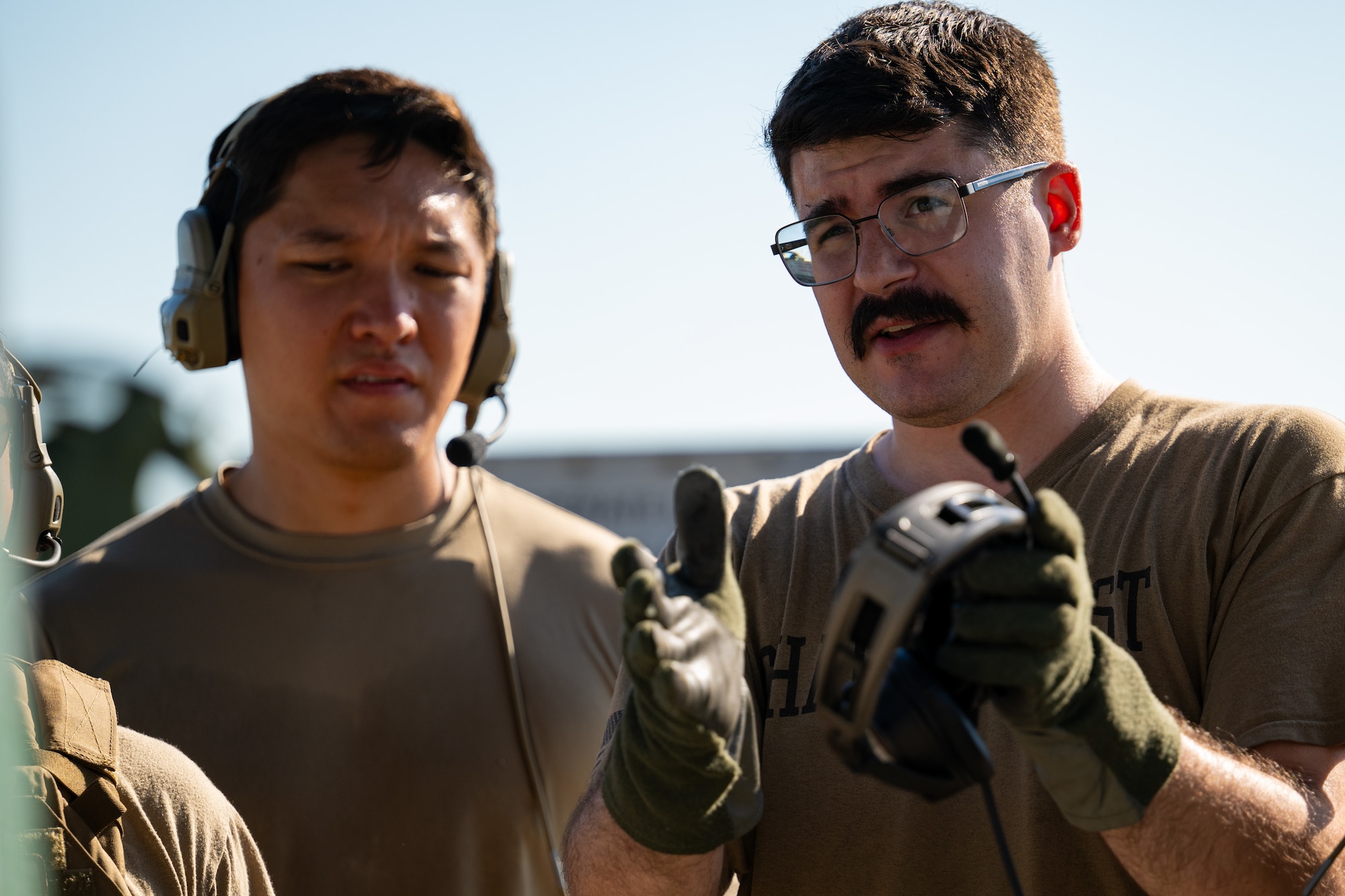 Senior Airman Colton Rucker, a loadmaster with the 130th Airlift Squadron, discusses with ground crew the loading of cargo on a C-130 J Super Hercules at Komatsu Airport, Japan on July 29, 2025. Air Mobility Command aircraft provide critical airlift and air refueling capabilities to project, connect, maneuver, and sustain the Joint Force during the REFORPAC and the first-in-a-generation Department-Level Exercise series. The DLE series encompasses all branches of the Department of Defense, along with Allies and partners, employing more than 400 Joint and coalition aircraft and more than 12,000 members at more than 50 locations across 3,000 miles. (U.S. Air Force photo by TSgt. Nicholas Monteleone)