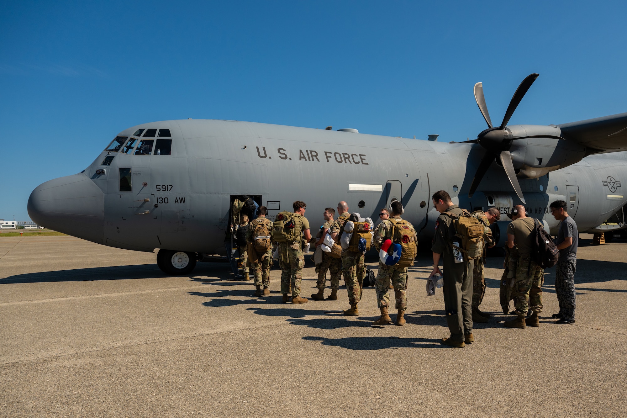 Passengers board a C-130J Super Hercules aircraft at Komatsu Airport, Japan, during Exercise Resolute Force Pacific 2025, July 29, 2025. Air Mobility Command aircraft provide critical airlift and air refueling capabilities to project, connect, maneuver, and sustain the Joint Force during the REFORPAC and the first-in-a-generation Department-Level Exercise series. The DLE series encompasses all branches of the Department of Defense, along with Allies and partners, employing more than 400 Joint and coalition aircraft and more than 12,000 members at more than 50 locations across 3,000 miles. (U.S. Air Force photo by Tech. Sgt. Nicholas Monteleone)