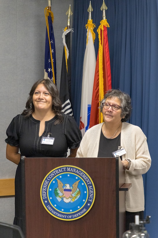 Two women stand at a podium