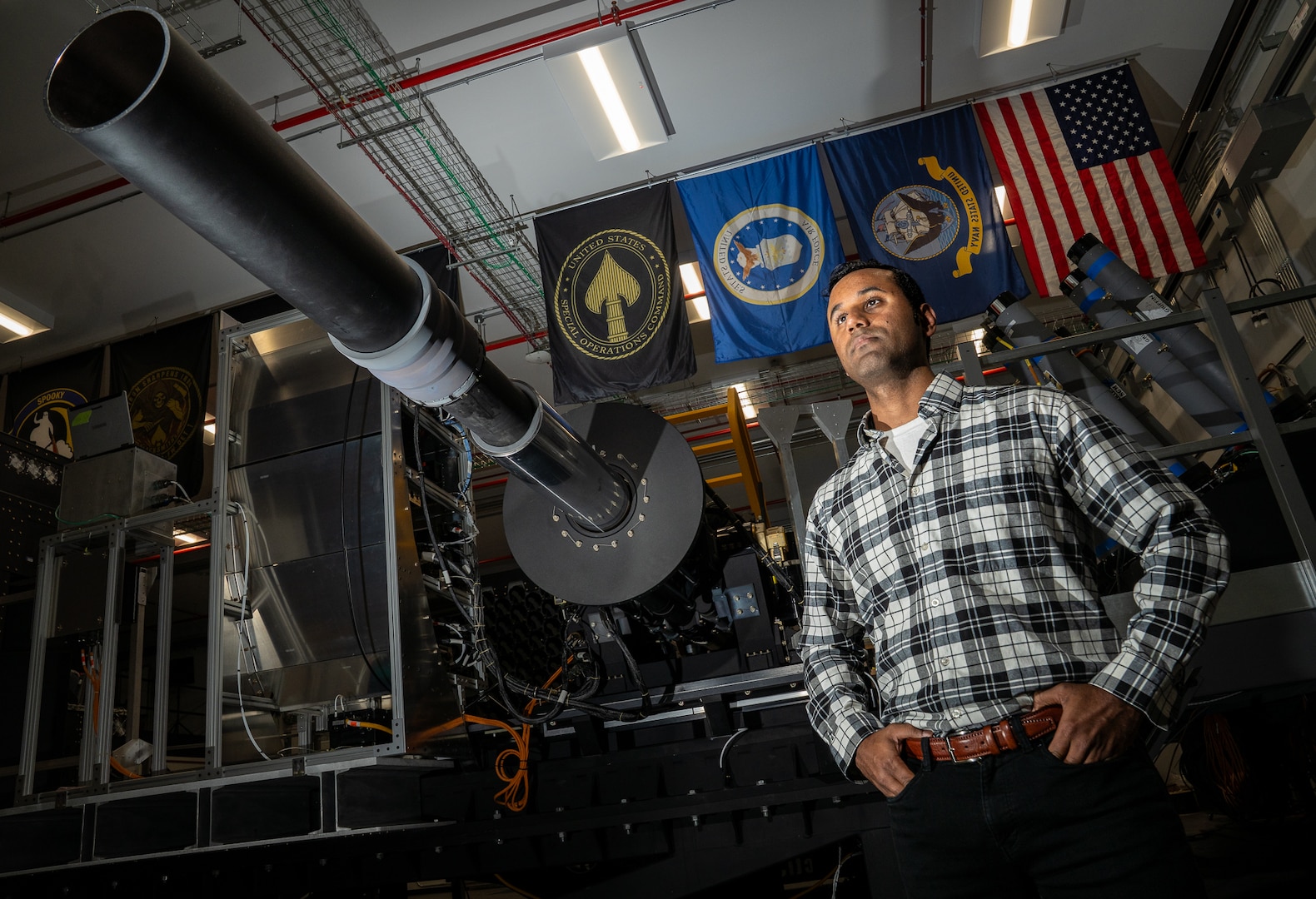 Engineer standing in front of flags in a lab