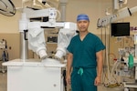 U.S. Army Col. (Dr.) Paul Hwang, director for surgery at Walter Reed, stands next to the microsurgical system used at the medical center for perform a successful breast reconstruction. The system allowed surgeons to reconnect very small blood vessels, usually done by hand and a large microscope, making the vessel connection more accurate and lessening the chances for possible complications, including collapse and clotting. (Graphic image by Roan Smith)