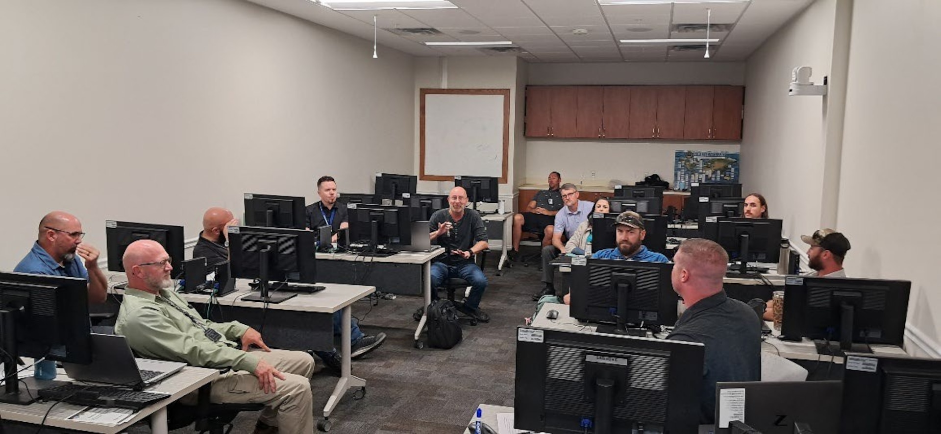 A group of employees sit at desks talking.